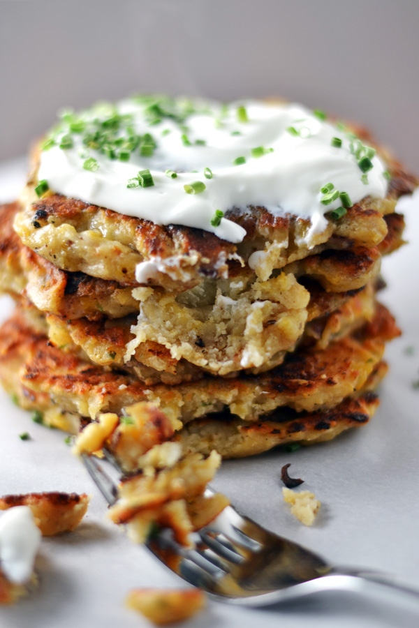 Close up view of Mashed Potato Bacon Pancakes with sour cream and chives ready to eat!