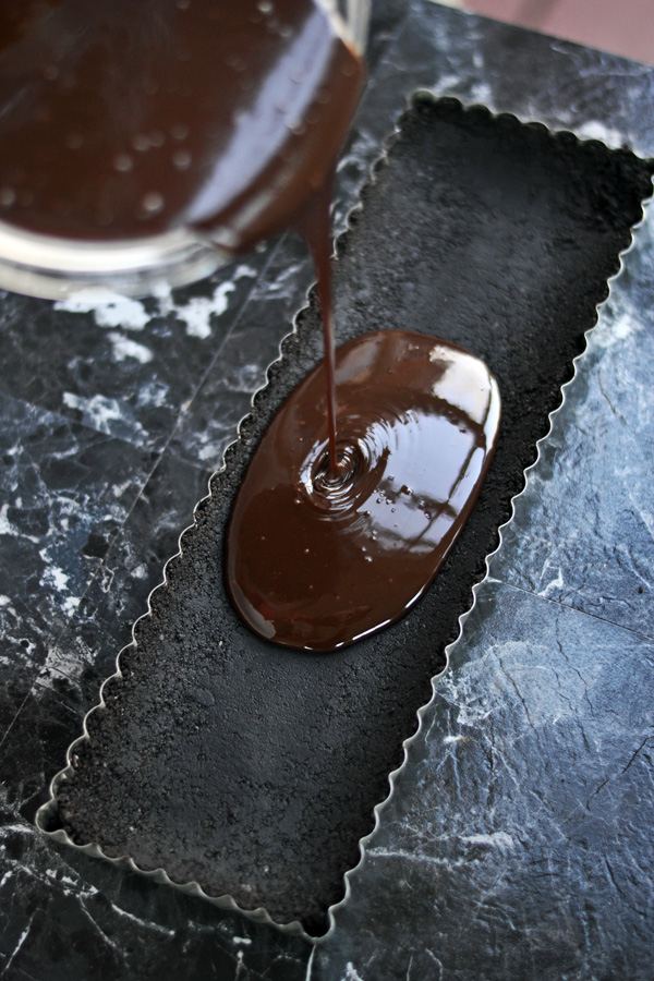 Pouring smooth chocolate filling for No Bake Strawberry Chocolate Tart